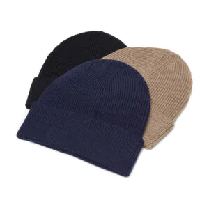 Knitted merino hats in pile. Colours black, blue and beige