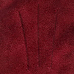 Close-up van drie klassieke sierstiksels en de fijne rood suede leerstructuur